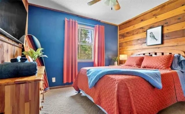 carpeted bedroom featuring ceiling fan and wood walls