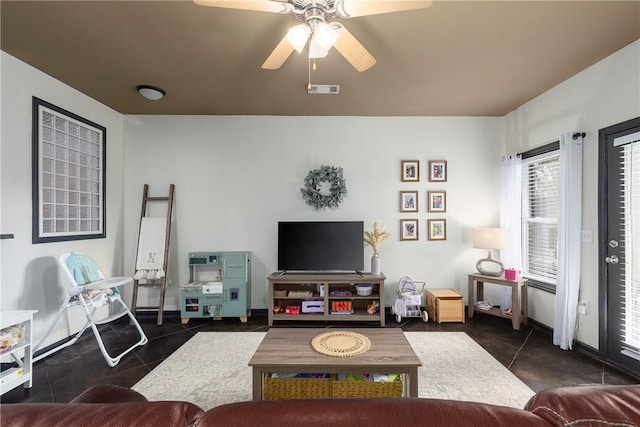 living room with dark tile patterned floors and ceiling fan