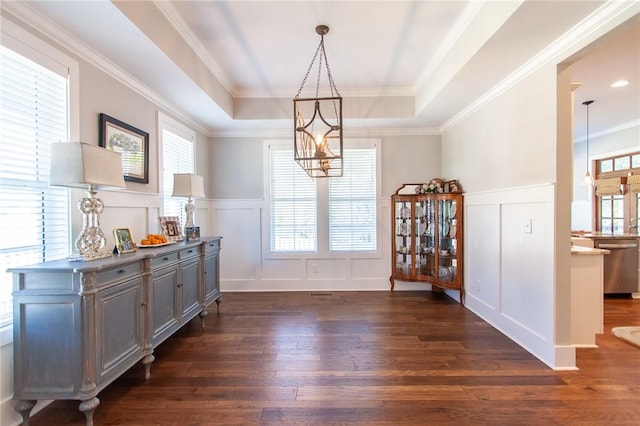 dining space with an inviting chandelier, dark hardwood / wood-style flooring, a raised ceiling, and crown molding