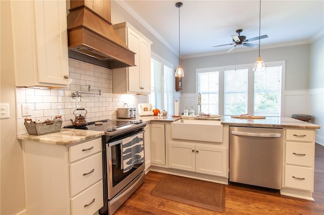 kitchen with hanging light fixtures, stainless steel appliances, white cabinets, custom exhaust hood, and kitchen peninsula