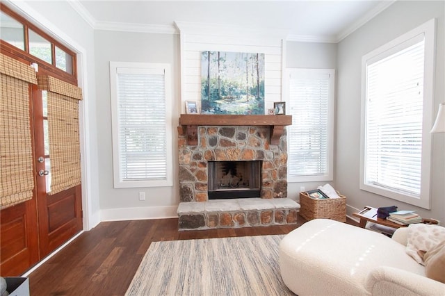 living room featuring dark hardwood / wood-style flooring, a stone fireplace, and crown molding