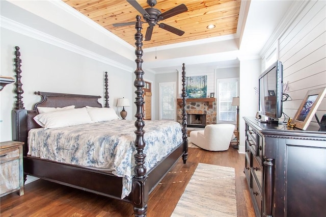 bedroom featuring dark wood-type flooring, ceiling fan, a tray ceiling, and wooden ceiling