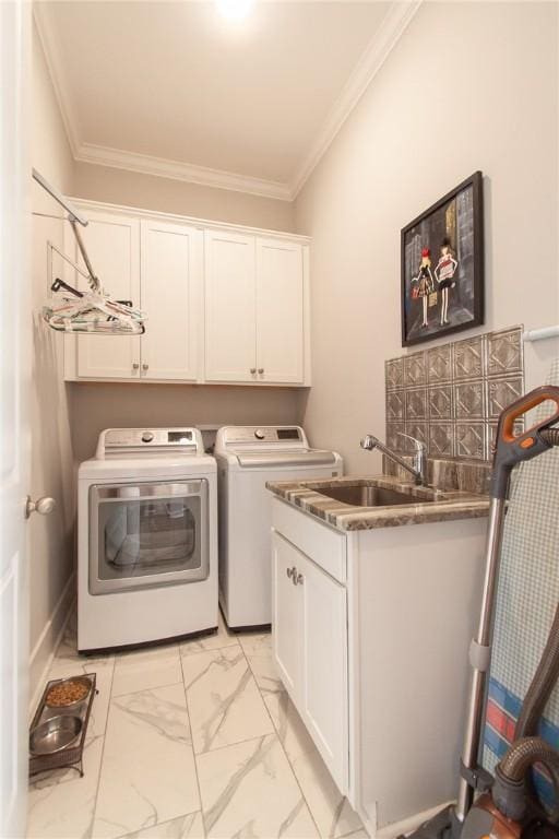 washroom featuring crown molding, cabinets, separate washer and dryer, and sink