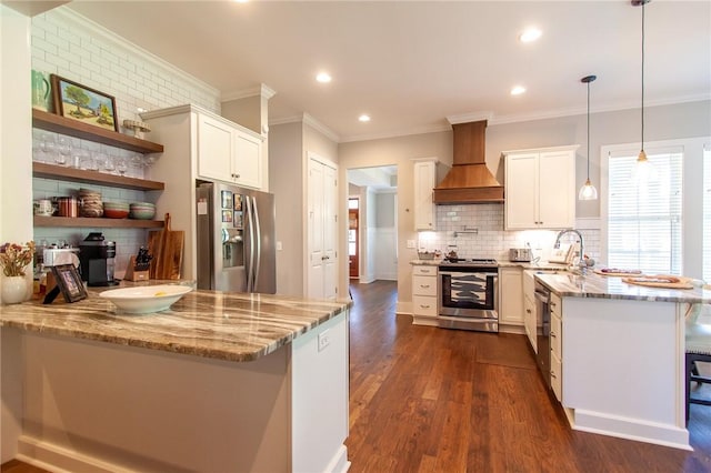 kitchen with pendant lighting, a breakfast bar, appliances with stainless steel finishes, white cabinetry, and custom exhaust hood