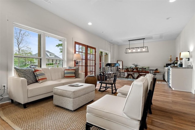 living room with french doors, recessed lighting, and light wood-style flooring