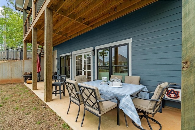view of patio with fence, french doors, and outdoor dining space