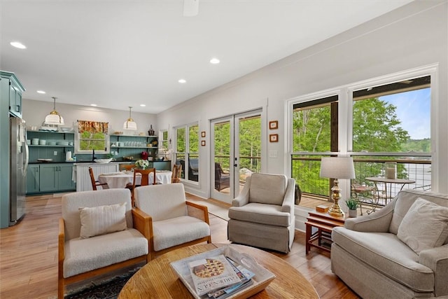 living area featuring light wood-style floors, recessed lighting, and french doors