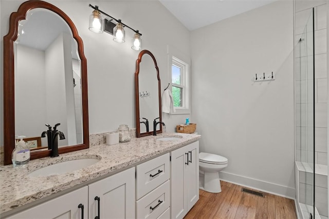 bathroom with visible vents, a sink, wood finished floors, and toilet