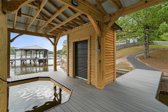 view of dock with a water view and fence