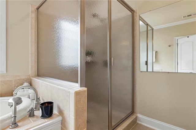 2182 Conservation Dr, Auburn, AL 36879 - bathroom featuring a shower stall, a bath, and ornamental molding