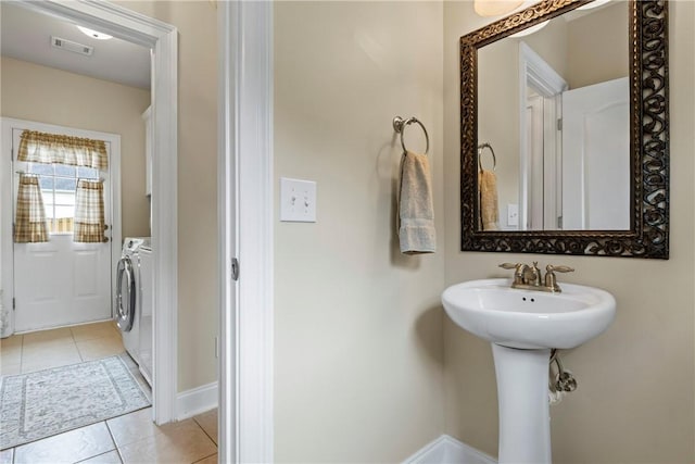 2182 Conservation Dr, Auburn, AL 36879 - bathroom with tile patterned floors, washing machine and dryer, a sink, and baseboards