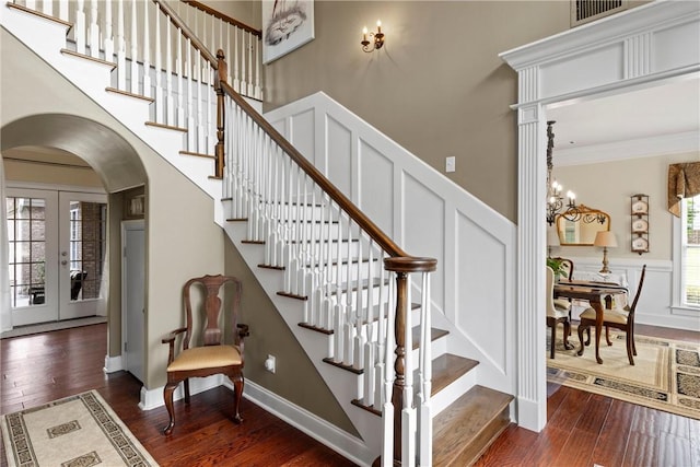 2182 Conservation Dr, Auburn, AL 36879 - stairs featuring arched walkways, wood finished floors, a decorative wall, a wainscoted wall, and ornamental molding