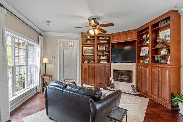 2182 Conservation Dr, Auburn, AL 36879 - living room featuring a ceiling fan, a fireplace, crown molding, and dark wood-type flooring
