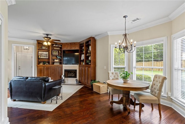 2182 Conservation Dr, Auburn, AL 36879 - dining space with a chandelier, wood finished floors, a fireplace, a ceiling fan, and ornamental molding