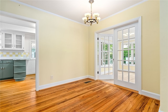 335 Woodfield Dr, Auburn, AL 36830 - unfurnished dining area with a chandelier, light wood finished floors, plenty of natural light, and ornamental molding