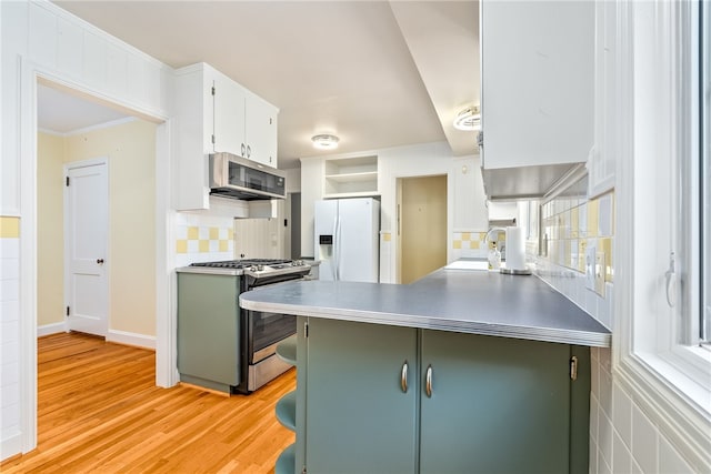 335 Woodfield Dr, Auburn, AL 36830 - kitchen with appliances with stainless steel finishes, light wood-style flooring, white cabinetry, decorative backsplash, and a peninsula