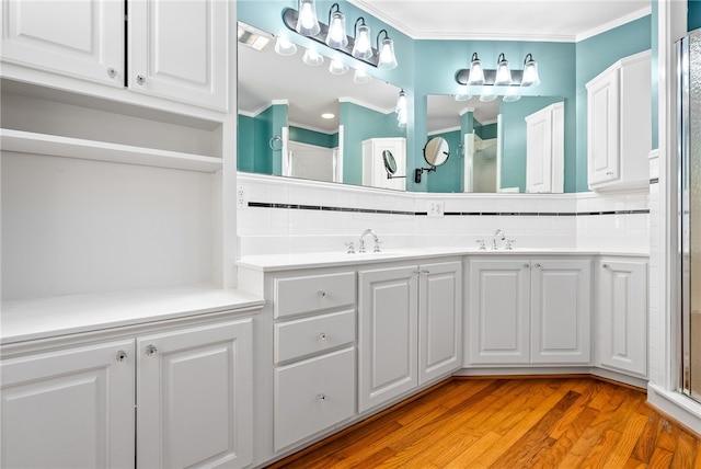 335 Woodfield Dr, Auburn, AL 36830 - bathroom featuring ornamental molding, double vanity, a shower with shower door, wood finished floors, and tasteful backsplash