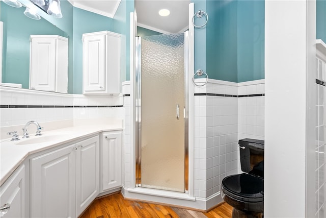 335 Woodfield Dr, Auburn, AL 36830 - bathroom featuring wood finished floors, vanity, a shower stall, tile walls, and ornamental molding