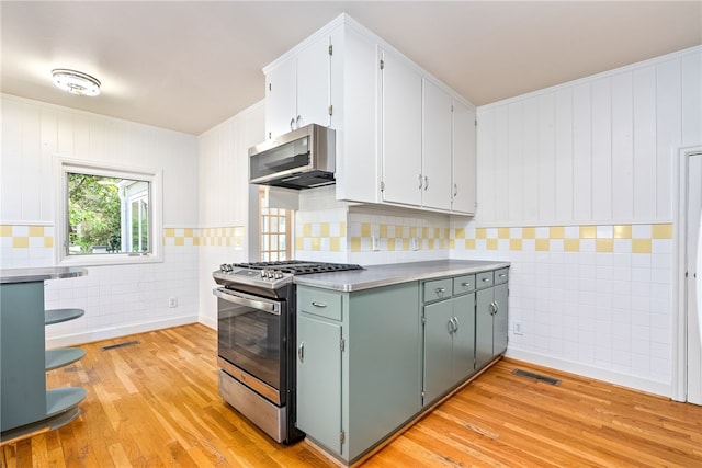 335 Woodfield Dr, Auburn, AL 36830 - kitchen with appliances with stainless steel finishes, tile walls, light wood-style flooring, and white cabinetry