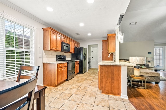 4339 Live Oak Dr, Auburn, AL 36830 - kitchen with black appliances, crown molding, brown cabinetry, a sink, and recessed lighting