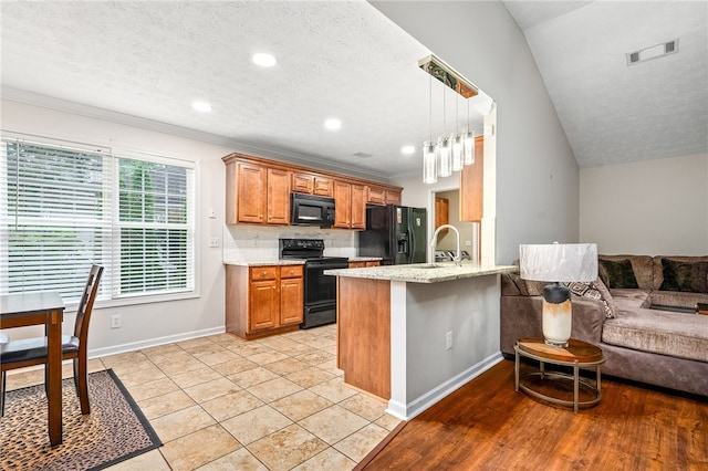 4339 Live Oak Dr, Auburn, AL 36830 - kitchen featuring black appliances, brown cabinets, open floor plan, a peninsula, and ornamental molding