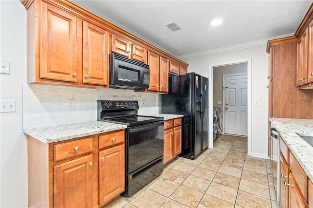 4339 Live Oak Dr, Auburn, AL 36830 - kitchen with black appliances, separate washer and dryer, backsplash, crown molding, and brown cabinetry