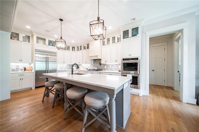 1659 N Donahue Dr, Auburn, AL 36830 - kitchen with stainless steel appliances, a sink, a chandelier, tasteful backsplash, and a kitchen island with sink