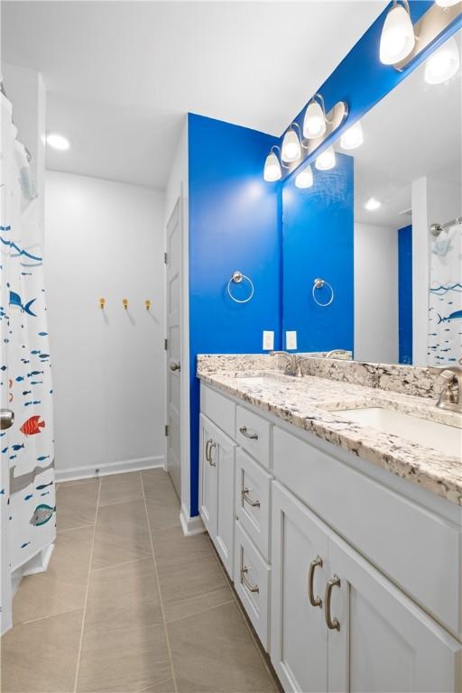 bathroom featuring tile patterned floors, vanity, and a shower with curtain