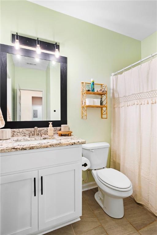 bathroom with curtained shower, tile patterned flooring, vanity, and toilet