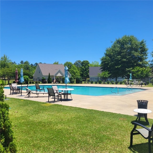 view of swimming pool with a lawn and a patio area