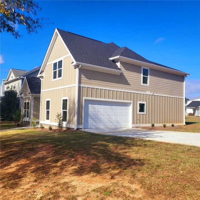 view of side of property with a yard and a garage