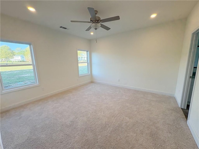 carpeted spare room featuring ceiling fan