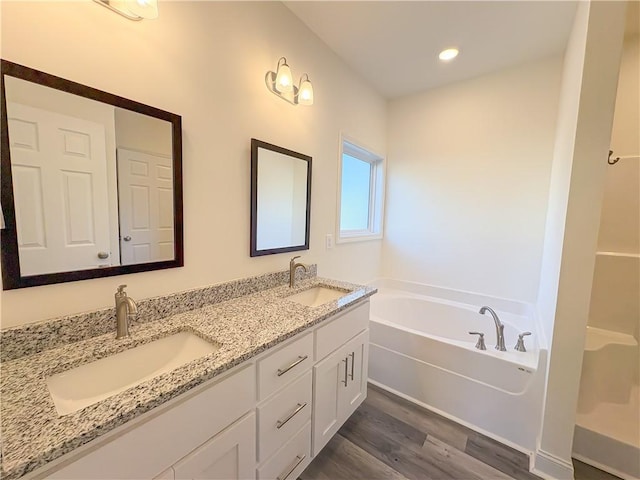 bathroom featuring a tub, vanity, and wood-type flooring