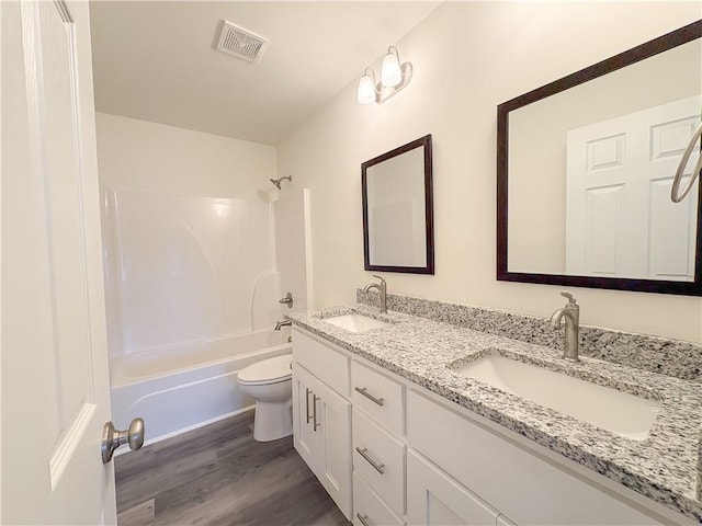 full bathroom featuring hardwood / wood-style floors, vanity, toilet, and shower / bath combination