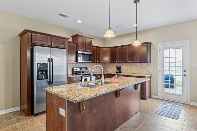 331 Lightness Dr, Auburn, AL 36830 - kitchen featuring appliances with stainless steel finishes, backsplash, a breakfast bar, a sink, and light tile patterned floors