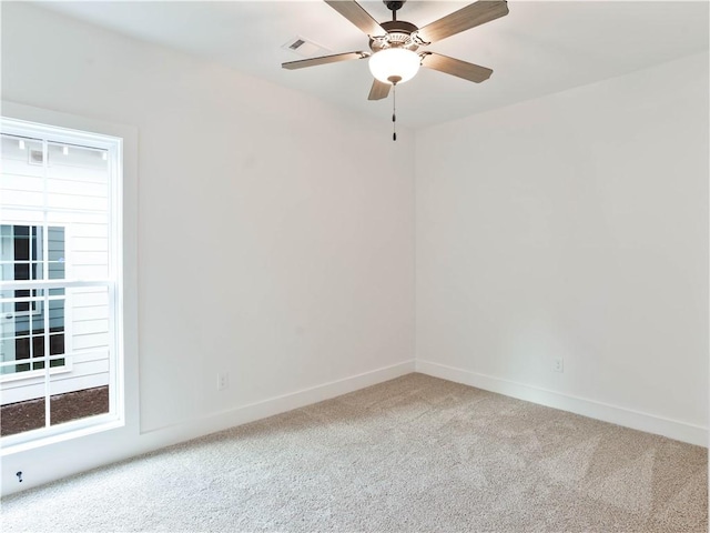 spare room with visible vents, baseboards, carpet, and a ceiling fan