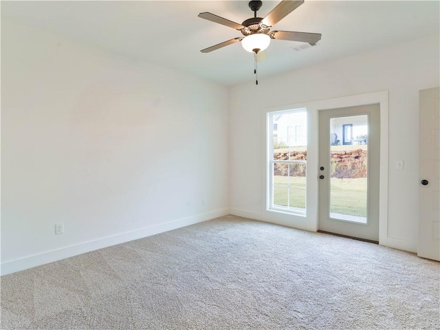 empty room featuring visible vents, baseboards, carpet, and a ceiling fan