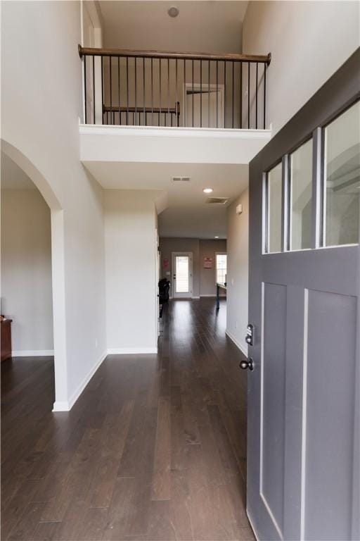 entrance foyer featuring a towering ceiling and dark hardwood / wood-style flooring