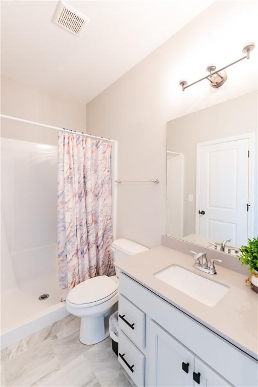 bathroom with vanity, curtained shower, and toilet