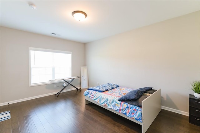 bedroom with dark hardwood / wood-style floors