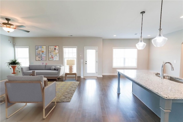 living room featuring ceiling fan, dark hardwood / wood-style flooring, sink, and a wealth of natural light