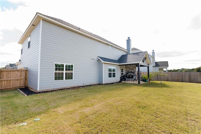 rear view of property featuring a lawn and a patio