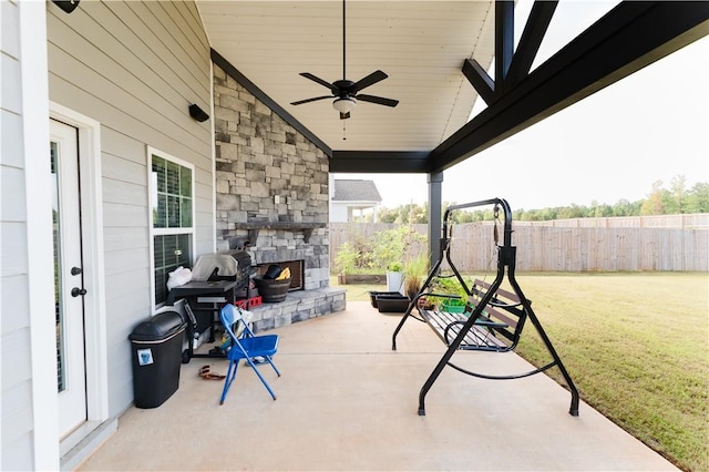 view of patio / terrace featuring an outdoor stone fireplace and ceiling fan