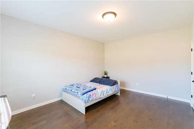 bedroom with dark hardwood / wood-style flooring