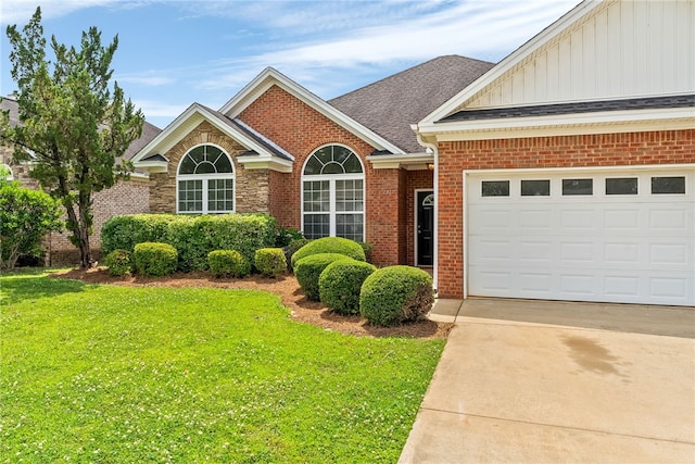 1317 Tulip Ct, Auburn, AL 36830 - view of front of home with board and batten siding, brick siding, concrete driveway, and a front yard