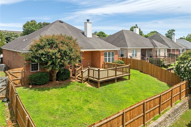 1317 Tulip Ct, Auburn, AL 36830 - back of property with brick siding, a deck, a fenced backyard, a chimney, and a shingled roof