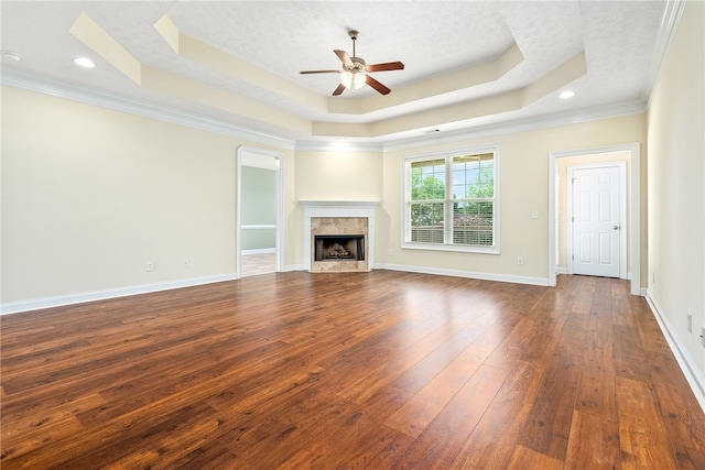 1317 Tulip Ct, Auburn, AL 36830 - unfurnished living room with a tray ceiling, ceiling fan, dark wood-style flooring, a premium fireplace, and crown molding