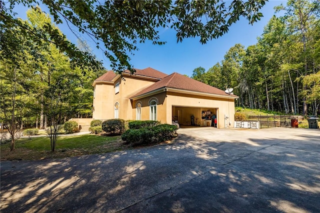 56 Peachwood Dr, Tallassee, AL 36078 - view of property exterior featuring driveway, an attached garage, and stucco siding