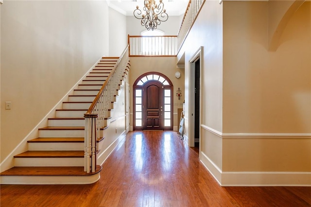 56 Peachwood Dr, Tallassee, AL 36078 - entrance foyer featuring baseboards, arched walkways, a chandelier, a towering ceiling, and wood finished floors