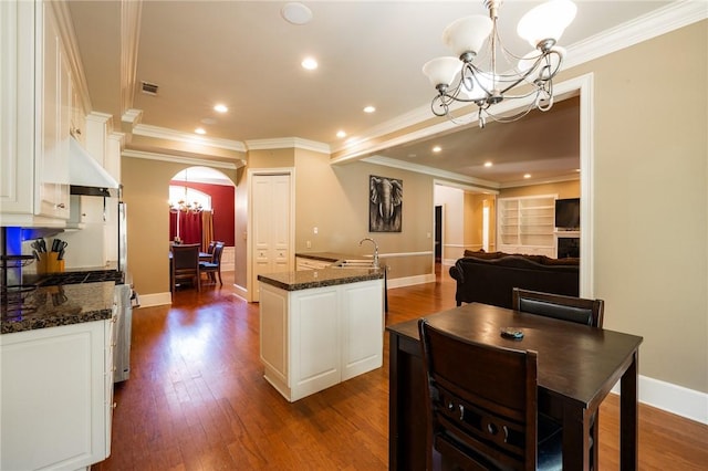 56 Peachwood Dr, Tallassee, AL 36078 - kitchen with a chandelier, under cabinet range hood, arched walkways, a sink, and dark wood-type flooring